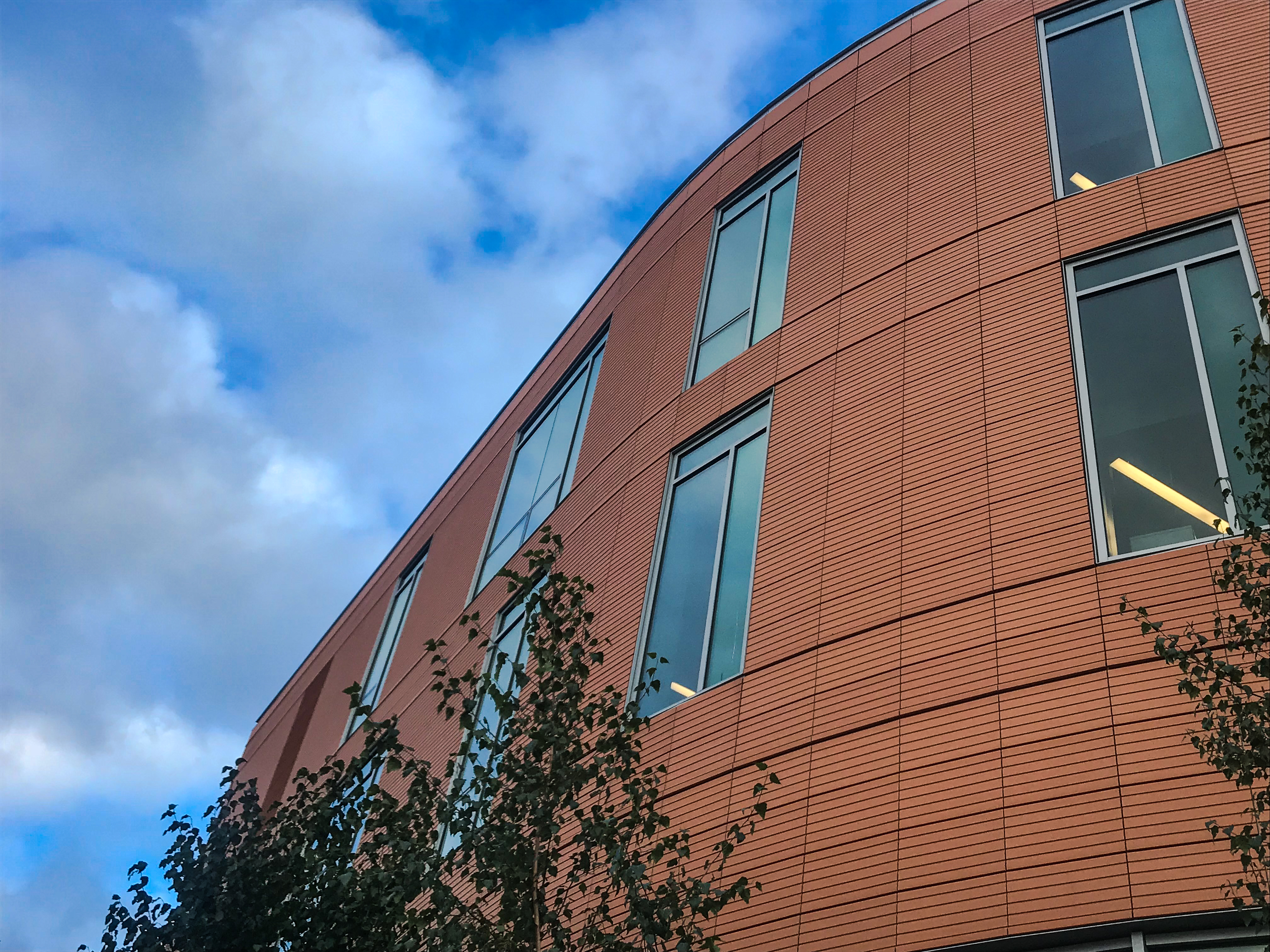 The standout façade features glass with profiled NBK terracotta panels in natural shades of an orange-red finish.